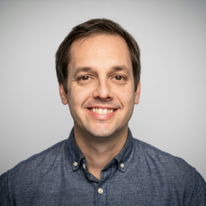 a-man-in-a-blue-shirt-smiling-at-the-camera